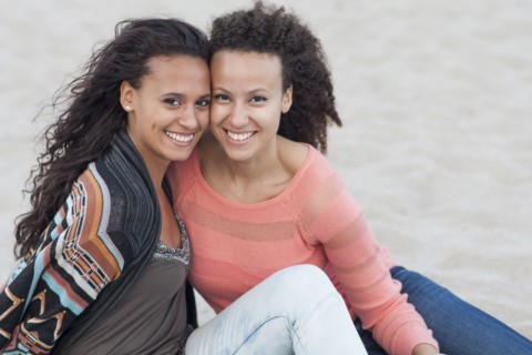 Smiling women hugging on beach