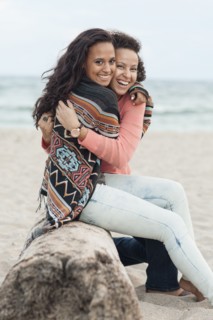 Smiling women hugging on beach