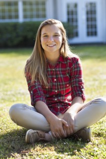 Caucasian girl sitting in backyard