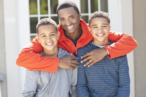 Father hugging sons outdoors