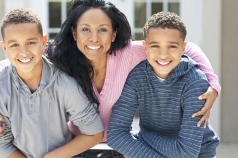 Close up of mother hugging sons outdoors