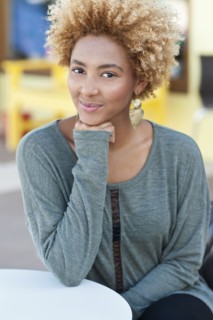 Black woman resting chin in hand outdoors