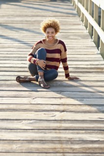 Black woman sitting on wooden boardwalk