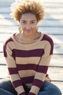 Black woman sitting on wooden boardwalk