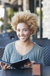 Black woman reading menu at cafe