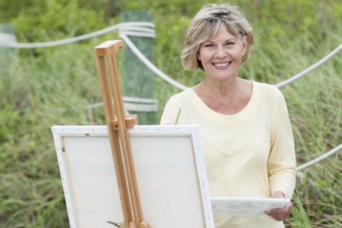 Older Caucasian woman painting outdoors