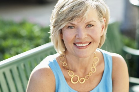 Smiling Caucasian woman sitting on bench