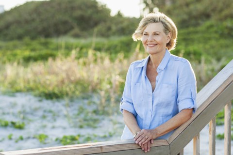 Smiling Caucasian woman standing on beach