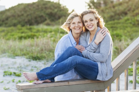 Caucasian mother and daughter hugging on beach