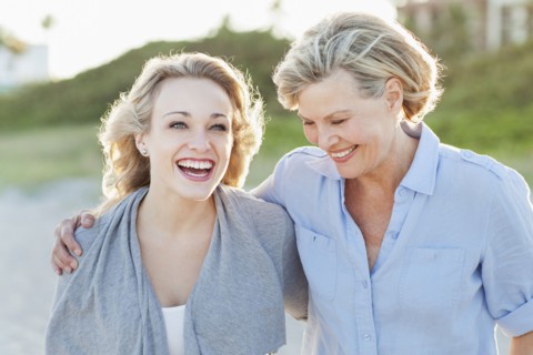 Caucasian mother and daughter hugging on beach