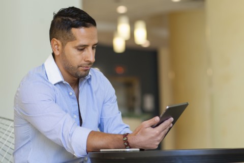 Hispanic man using digital tablet