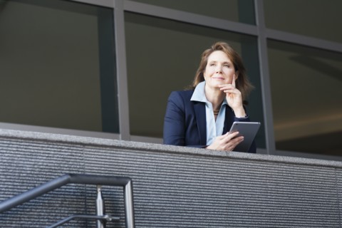 Caucasian businesswoman using digital tablet on balcony