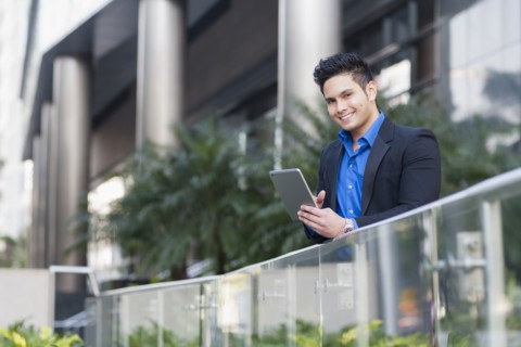 Mixed race businessman using digital tablet outdoors
