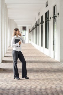 Caucasian businesswoman talking on cell phone in hallway