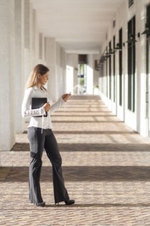 Caucasian businesswoman using cell phone in hallway
