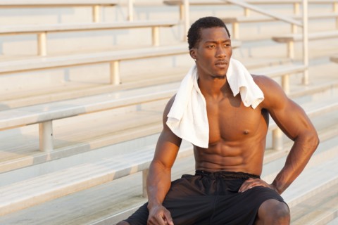 Black athlete sitting on bleachers