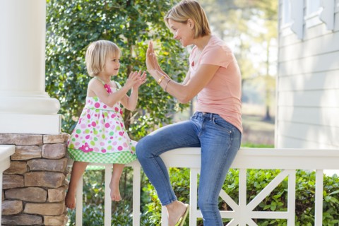 Caucasian mother and daughter playing on patio