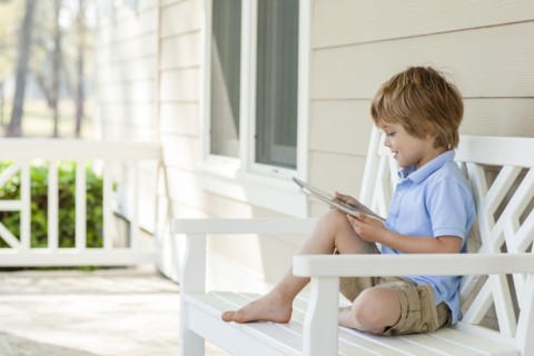 Caucasian boy using digital tablet on patio