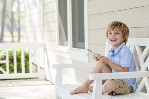 Caucasian boy using digital tablet on patio