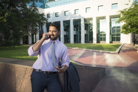 Indian businessman talking on cell phone outside office building