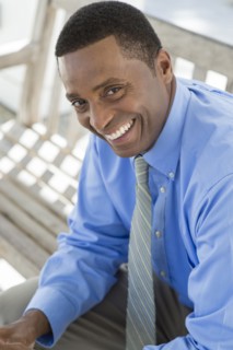 Black businessman smiling on bench