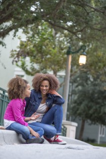 Mixed race mother and daughter sitting outdoors