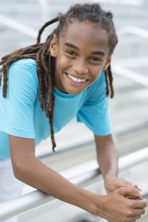Mixed race boy smiling on bleachers