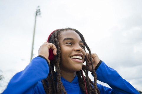 Mixed race boy listening to headphones outdoors