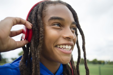 Mixed race boy listening to headphones outdoors