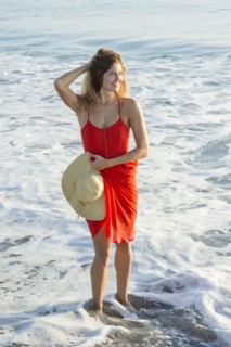 Caucasian woman standing in waves on beach