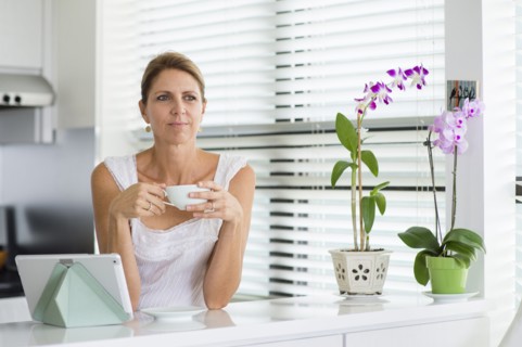 Caucasian woman drinking coffee in kitchen