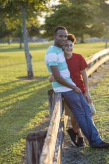 Father and son hugging at fence
