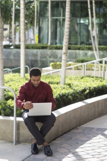 Black businessman using laptop outdoors
