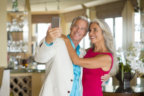 Older Caucasian couple taking selfie