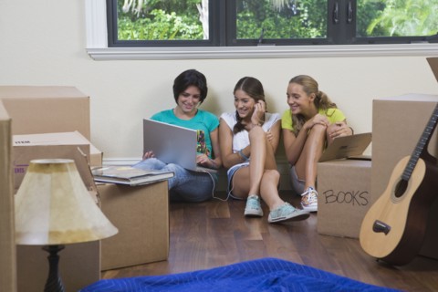 Hispanic teenage girls and woman using laptop