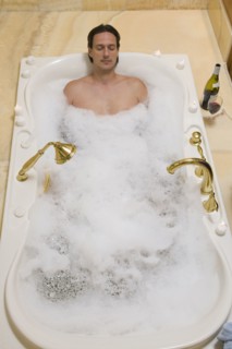 Hispanic man relaxing in bubble bath