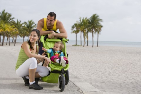 Hispanic couple stopping with baby in jogging stroller