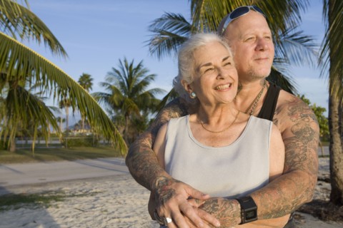 Mother and tattooed son hugging at the beach