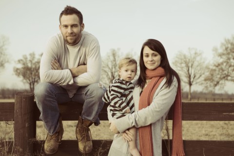 Caucasian family standing near wooden fence