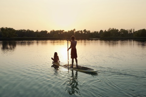 Caucasian boy and girl on paddleboard on lake