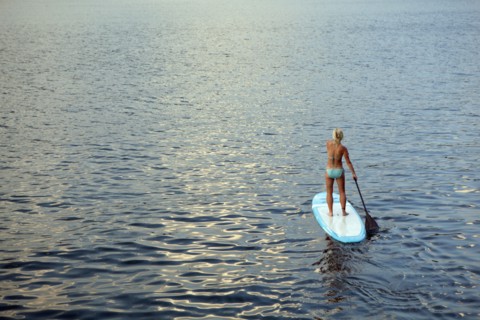 Caucasian woman on paddleboard on lake