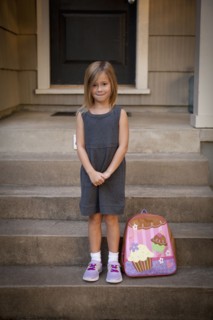 Caucasian girl with backpack on front steps