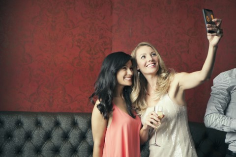 Women taking picture together in nightclub
