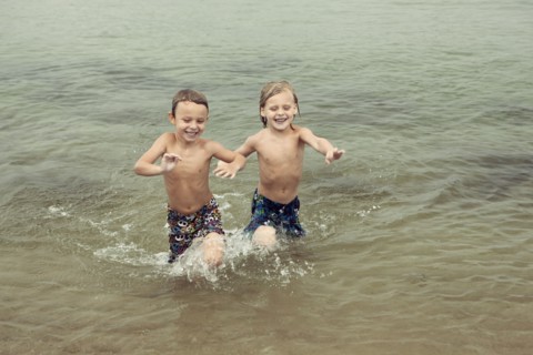 Caucasian boys playing in lake