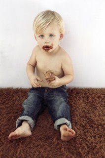 Messy Caucasian boy eating chocolate ice cream cone
