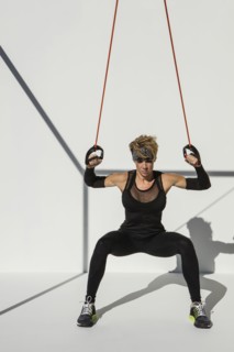 Caucasian athlete exercising with resistance cables