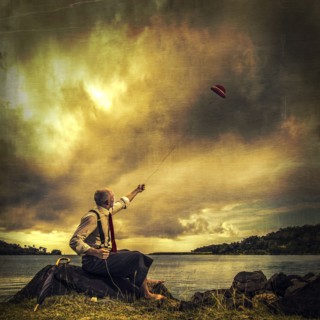 Caucasian man flying derby kite near remote lake
