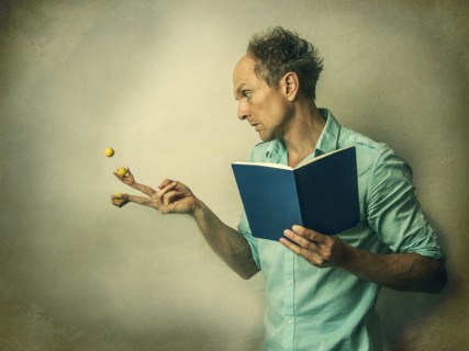 Caucasian man juggling fruit with finger hands