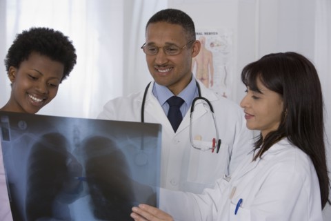 Multi-ethnic doctors and patient looking at x-ray