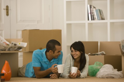 Young couple next to unpacked moving boxes